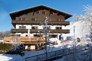 uma grande casa de madeira com neve no chão em Sonnenburg Hotel em Ehrwald