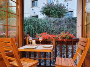 un tavolo e sedie su un patio fiorito di Nuevo-Casco Histórico-Parking gratuito. a Oviedo