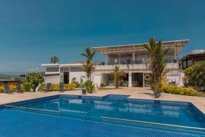 a swimming pool in front of a house at Hotel Resort Del Cafe in Manizales