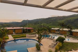 馬尼薩萊斯的住宿－Hotel Resort Del Cafe，一座带游泳池和山脉的度假村