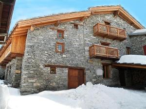 un edificio de piedra con balcón de madera. en Chalet Alpin en Val Cenis