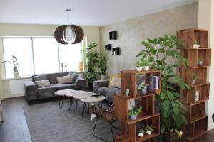 ein Wohnzimmer mit einem Sofa und einem Tisch in der Unterkunft Bed and garden in Knokke-Heist