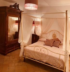 a bedroom with a canopy bed and a mirror at DON GIL CHIC in Polignano a Mare