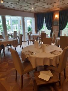 a dining room with tables and chairs and windows at Locanda Rondolost in Cencenighe