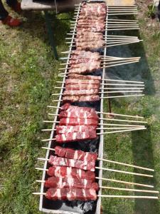a row of skewers cooking meat on a grill at Locanda Rondolost in Cencenighe