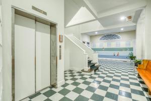 un couloir d'un immeuble avec un sol en damier dans l'établissement The Goose Getaway, à Savannah