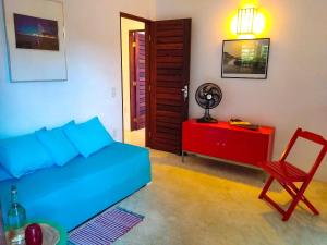 a bedroom with a blue bed and a red dresser and a chair at Castelo Vendôm Ecolodge Parajuru in Parajuru