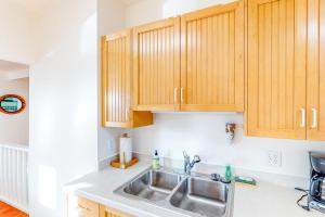 a kitchen with a sink and wooden cabinets at Cottage at Nye Beach in Newport