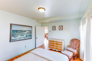 a living room with a bed and a chair at Cottage at Nye Beach in Newport