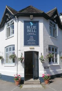 Biały budynek z niebieskim dzwonkiem w obiekcie The Blue Bell w mieście Midhurst