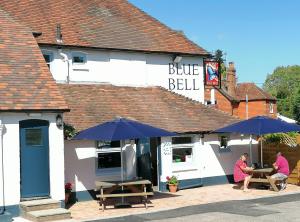 two people sitting at a table outside of a blue bell restaurant at The Blue Bell at Cocking in Midhurst
