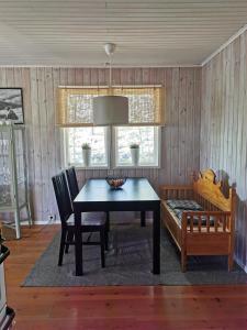 ein Esszimmer mit einem Tisch, Stühlen und einem Fenster in der Unterkunft Fjällstuga i Foskros m bastu in Idre