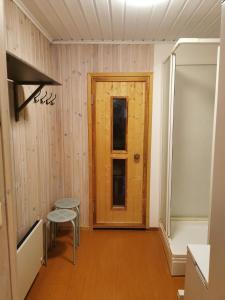 una camera con porta in legno, sgabello e sedia di Fjällstuga i Foskros m bastu a Idre