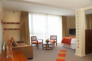 a hotel room with a bed and a living room at Solace Hotel Puerto Varas in Puerto Varas