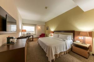 a hotel room with a bed and a desk at Holiday Inn Guadalajara Select, an IHG Hotel in Guadalajara