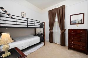 a bedroom with a bunk bed and a dresser at Bakers Retreat in Hobart