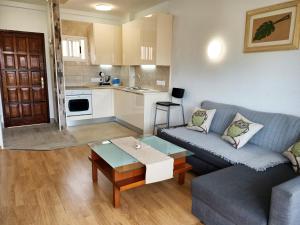 a living room with a couch and a table at Sea view 1B Los Cristianos in El Guincho