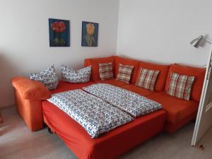 un divano rosso con cuscini in una stanza di Ferienwohnung Hutzfeld Tammi a Oberaudorf