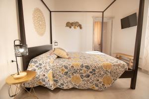 a bedroom with a bed and a table with a lamp at Piombino 1428 in Piombino