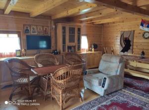 ein Wohnzimmer mit einem Tisch, Stühlen und einem TV in der Unterkunft Suncevica Apartmani in Arilje