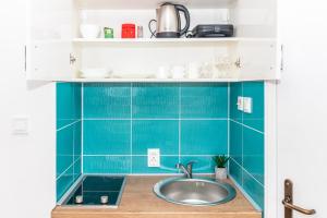 a kitchen with a sink and a blue tiled wall at Bossa nova Apartment in Herceg-Novi +16 photos