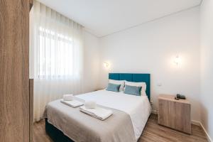 Un dormitorio con una cama grande con dos toallas encima. en Hotel Grande Rio, en Oporto