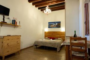 a bedroom with a bed and a dresser and a chandelier at Ca' del Megio in Venice