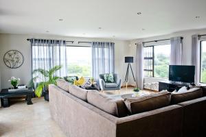 sala de estar con sofá grande y TV en Aguia-Vista Paradise Bliss, 3BR, Pool, Beach Walk, en Jeffreys Bay