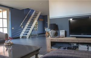 a living room with a flat screen tv and a staircase at KoksenCo in Stevensbeek