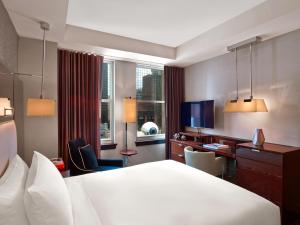 a hotel room with a large bed and a desk at The Joule in Dallas