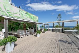 eine Terrasse mit Tischen und Stühlen auf einem Gebäude in der Unterkunft Georgioupolis Beach Hotel in Georgioupoli