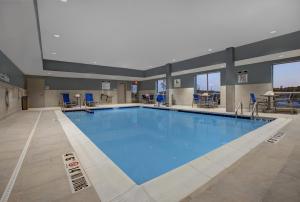 a large swimming pool with blue water at Holiday Inn Express & Suites - Milwaukee - Brookfield, an IHG Hotel in Brookfield