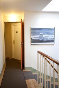 a hallway with a staircase and a painting on the wall at Nadaud Hotel in Paris