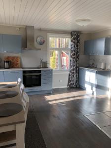 a kitchen with blue cabinets and a table and a window at Villa Taivaanvuohi in Kyrö