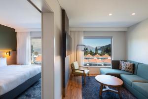 Holiday Inn Express & Suites Queenstown, an IHG Hotel في كوينزتاون: غرفه فندقيه بسرير واريكه