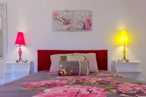 een slaapkamer met een bed met roze bloemen erop bij Recanto das Florenças (2) in Arco da Calheta