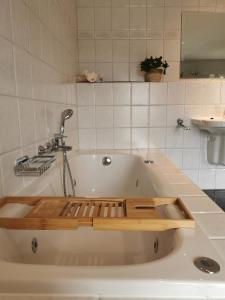 a bath tub with a faucet in a bathroom at Blief bie de Mam in Echt