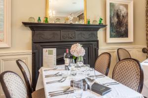 a dining room with a table and chairs and a fireplace at Kells Bay House and Gardens in Kells