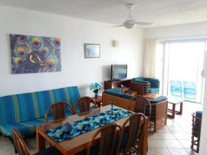 a living room with a couch and a table and chairs at 197 Stella Maris in Amanzimtoti