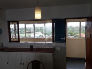 a kitchen with two windows and a view of a city at 197 Stella Maris in Amanzimtoti +14 photos
