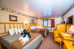 a hotel room with two beds and a desk at Spearfish Canyon Lodge in Spearfish