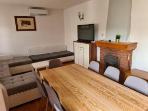 a room with a table and a fireplace and a couch at Apartman Max in Sveti Ivan Zelina