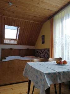 a dining room with a table and a bed at Ubytovanie Gerlachov - Anna Bajzikova in Svätý Jur