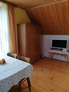 ein Wohnzimmer mit einem Tisch und einem TV in der Unterkunft Ubytovanie Gerlachov in Gerlachov