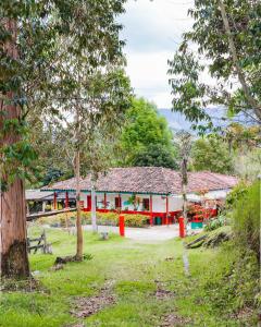 a red and white building with trees in front of it at Ecofinca Salento in Salento