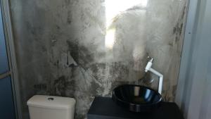 a bathroom with a toilet and a sink at Pousada Casa de Ferro in Passo de Torres +51 photos