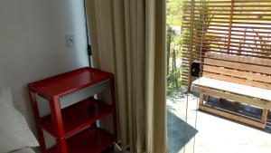 a room with a red shelf next to a window at Pousada Casa de Ferro in Passo de Torres
