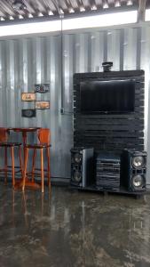 a room with a table and a tv and speakers at Pousada Casa de Ferro in Passo de Torres
