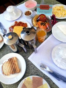 una mesa cubierta con platos de comida y utensilios en Pousada Mar e Sol en Pipa