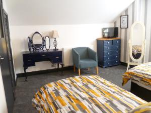 a bedroom with a bed and a desk and a chair at Charming Spacious Apartment, Kidderminster in Kidderminster